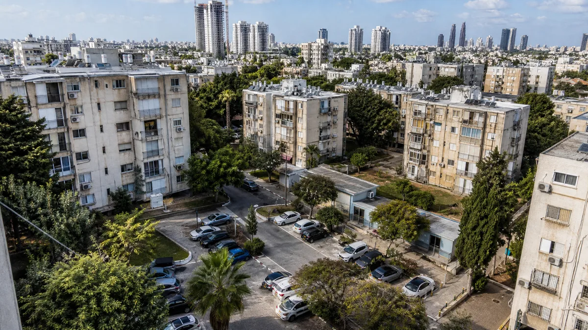 מבט עירוני על בניינים ותיקים סביב חצר וחניות לבדיקת צפיפות קיימת בפינוי־בינוי